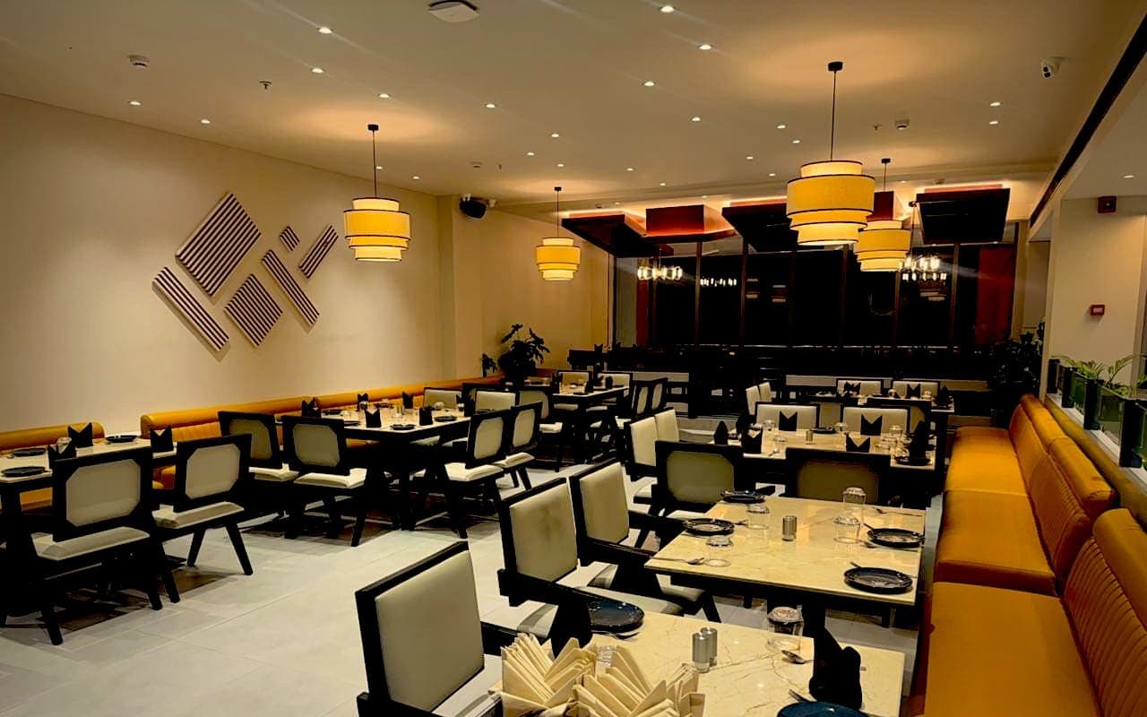 Mustard banquettes and lantern lights in the main dining room